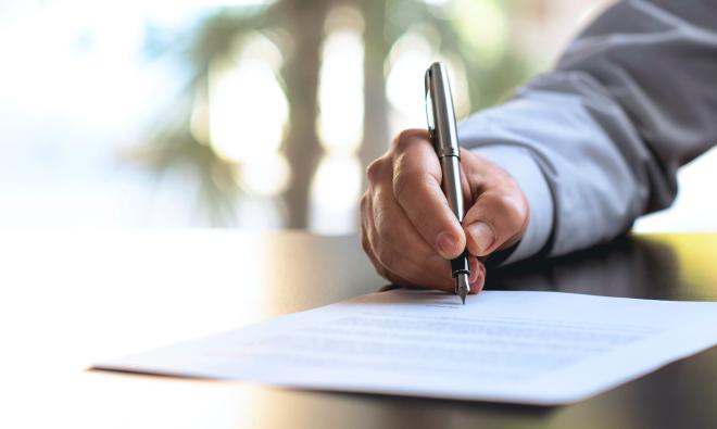 man writing on paper