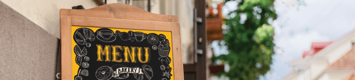Outdoor a-frame menu board produced with Nekoosa's ChalkTalk® chalkboard vinyl placed in front of a bakery.
